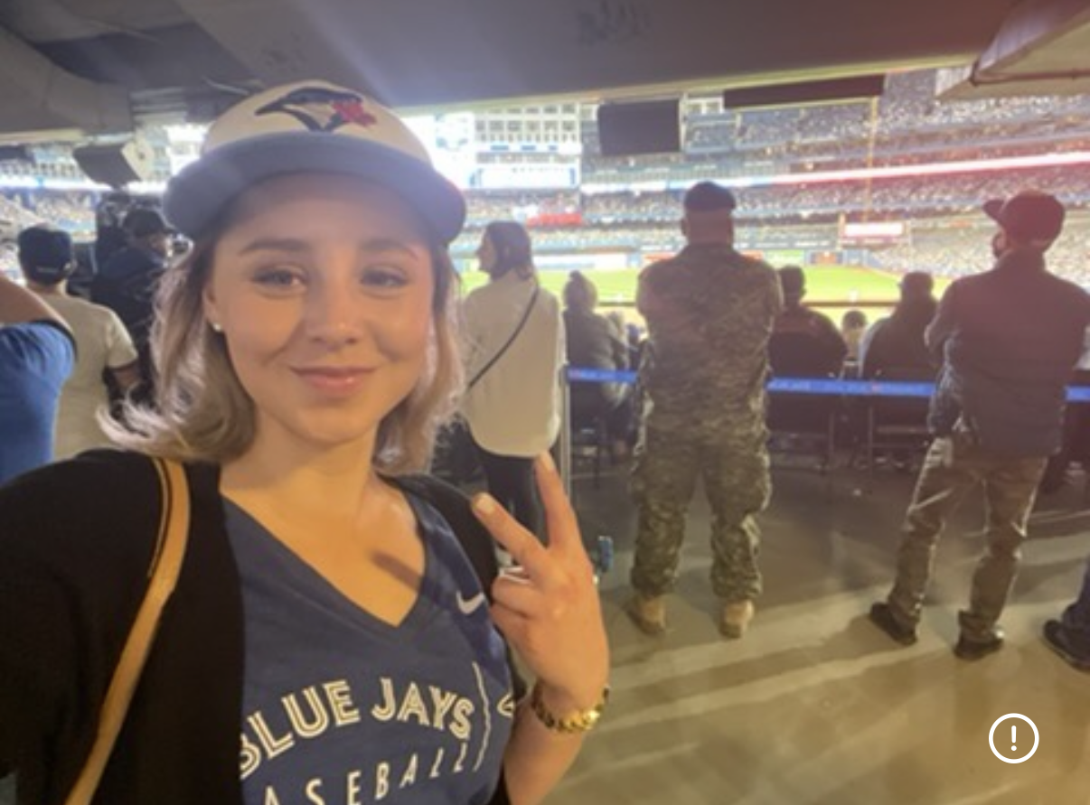 Brittany wearing a Toronto Blue Jays hat and jersey at the ballpark