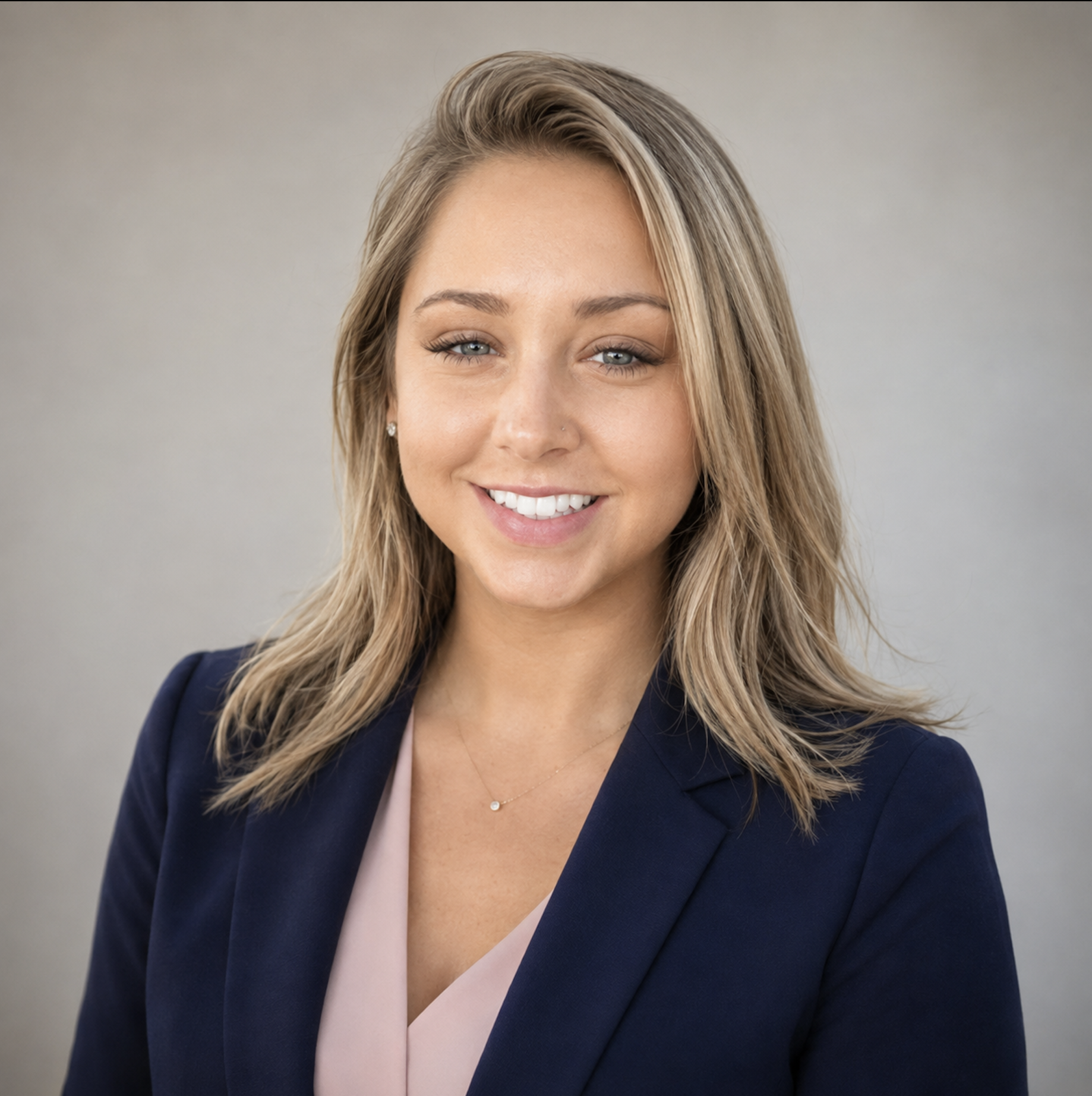 Brittany Saunders smiling in a navy blazer and blush blouse